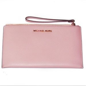 Light pink Michael Kors purse with hand strap.